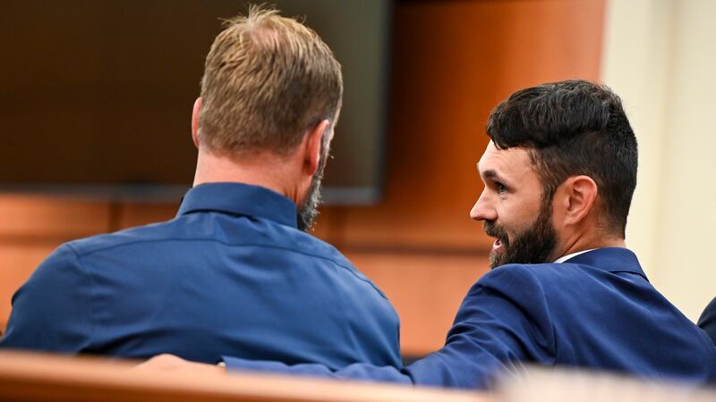 Defendants Matthew Collins, left, and Christopher "Shane" Burbank talk in the gallery during...
