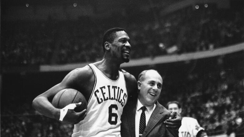 FILE - Bill Russell, left, star of the Boston Celtics is congratulated by coach Arnold "Red"...