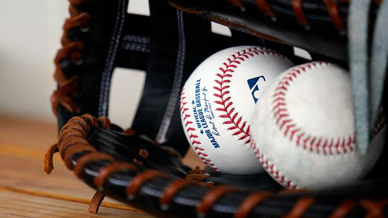 A pair baseballs and a glove sit in the Milwaukee Brewers dugout prior to a spring training...